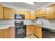 Bright kitchen with granite countertops, wood cabinets, and modern appliances at 13626 E Bates Ave # 207, Aurora, CO 80014