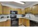 Kitchen with granite countertops, wood cabinets, and black appliances at 13626 E Bates Ave # 207, Aurora, CO 80014