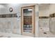 Locker room with tiled walls and floors, bench seating and access to the sauna at 13626 E Bates Ave # 207, Aurora, CO 80014