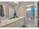 Well-lit bathroom with white cabinets, a large mirror, and a shower-tub combo at 1005 Alpine Aven St, Henderson, CO 80640