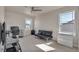 Bright bedroom with multiple windows and a black futon at 1005 Alpine Aven St, Henderson, CO 80640