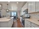 Modern kitchen featuring white cabinetry, stainless steel appliances, and eat in dining area at 1005 Alpine Aven St, Henderson, CO 80640