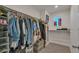 Spacious walk-in closet featuring ample hanging space and shelving with a window for natural light at 1005 Alpine Aven St, Henderson, CO 80640