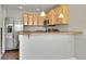 A bright kitchen with stainless steel refrigerator and light wood cabinets that offer ample storage and modern appeal at 8848 Prickly Pear Cir, Parker, CO 80134