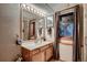 Comfortable bathroom with a single sink, framed mirror with lighting, window, and a shower at 9658 Coronado Ct, Parker, CO 80134