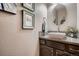 Stylish powder room featuring a modern vessel sink, decorative mirror, and unique wall art at 9658 Coronado Ct, Parker, CO 80134