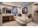 A luxurious bathroom featuring a large soaking tub with tiled steps and a separate glass-enclosed shower at 9658 Coronado Ct, Parker, CO 80134