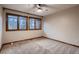 A simple bedroom with neutral carpet, two windows, and trim details at 9658 Coronado Ct, Parker, CO 80134