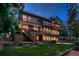 Expansive three-story home with large windows, outdoor deck, hot tub, and lush lawn at 9658 Coronado Ct, Parker, CO 80134