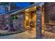 Covered front porch with brick columns, a decorative front door, and Adirondack chairs at 9658 Coronado Ct, Parker, CO 80134
