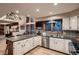 Modern kitchen with white cabinetry, a large island, and stylish backsplash at 9658 Coronado Ct, Parker, CO 80134