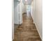 Long hallway featuring hardwood flooring, white walls, multiple doorways, and ample natural light at 762 Penn Rd, Elizabeth, CO 80107