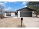 Updated ranch home with dark gray accents and a two-car garage at 6714 Depew St, Arvada, CO 80003