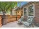 Inviting front porch with comfortable chairs and a charming fence with beautiful flowering plants at 9193 W 7Th Ave, Lakewood, CO 80215