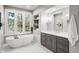 Bright bathroom with a standalone tub, double vanity, and marble-look tile flooring at 254 Lead Queen Dr, Castle Rock, CO 80108