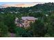 Stunning home exterior nestled amongst lush trees and landscaping at dusk at 254 Lead Queen Dr, Castle Rock, CO 80108