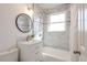 Updated bathroom with modern fixtures, marble tile, and bright lighting at 1476 W Dakota Ave, Denver, CO 80223