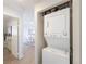 Hallway view showing a white stacked washer and dryer in an alcove at 1476 W Dakota Ave, Denver, CO 80223