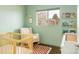 Serene Bedroom with a wood crib, red patterned rug, rocking chair, and wall shelves with books at 2432 S Newport St, Denver, CO 80224