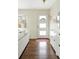 Bright entryway featuring wood floors, white storage cabinet, and decorative mirror at 2432 S Newport St, Denver, CO 80224