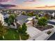 Sunset aerial view of a home with a driveway, large yard, and mature trees at 3107 S Nepal Way, Aurora, CO 80013