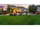 Well-manicured backyard with outdoor dining, fire pit, and lush green lawn at 3107 S Nepal Way, Aurora, CO 80013