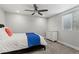 Neutral bedroom with a window, fan, and a bed with white linens and blue accents at 3107 S Nepal Way, Aurora, CO 80013