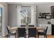 Dining area with a wooden table, gray chairs, modern light fixtures, and bright natural light at 3107 S Nepal Way, Aurora, CO 80013