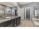 This bathroom offers double sinks with granite counters, tub, and tiled walk-in shower at 3107 S Nepal Way, Aurora, CO 80013