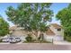 Exterior facade of townhomes with attached garages, mature trees and manicured lawns at 461 S Kalispell Way # D, Aurora, CO 80017