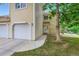 This townhome exterior features tan siding, an attached garage, and a well-maintained lawn at 461 S Kalispell Way # D, Aurora, CO 80017