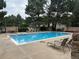 Community pool area surrounded by lounge chairs, mature trees and decorative stone fencing at 461 S Kalispell Way # D, Aurora, CO 80017