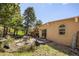 Serene backyard featuring a stone patio, outdoor seating, mature trees, and natural landscaping at 107 Elk Dr, Evergreen, CO 80439