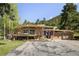 Well maintained, mid-century modern home with large attached two car garage surrounded by lush landscape and mature trees at 107 Elk Dr, Evergreen, CO 80439