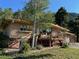 A long view of the back side of the home with a patio and lots of mature trees around the property at 107 Elk Dr, Evergreen, CO 80439