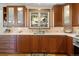 Kitchen with wood cabinets, mosaic backsplash, quartz countertops, stainless steel appliances and a large window at 107 Elk Dr, Evergreen, CO 80439