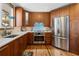 Kitchen with wood cabinets, stainless steel appliances, quartz countertops, and tile backsplash at 107 Elk Dr, Evergreen, CO 80439