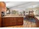 Open concept kitchen with wood cabinets, stainless steel appliances, and breakfast bar overlooking the living and dining rooms at 107 Elk Dr, Evergreen, CO 80439