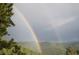 Mountainous view with green trees and a double rainbow at 107 Elk Dr, Evergreen, CO 80439