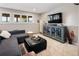 Cozy living room featuring a comfortable sectional, entertainment center, and serene outdoor views from the windows at 107 Elk Dr, Evergreen, CO 80439