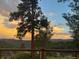 Lovely sunset view from the deck over a mountain range with lots of trees at 107 Elk Dr, Evergreen, CO 80439