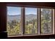 Scenic view of mountain landscape from a window, showcasing lush trees and distant peaks under a clear sky at 107 Elk Dr, Evergreen, CO 80439