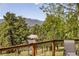 Enjoy the serene mountain view from the wooden deck overlooking lush trees at 107 Elk Dr, Evergreen, CO 80439