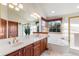 Bright bathroom featuring double sinks, a jetted tub under a window, and a tiled shower with glass door at 8187 N Pinewood Dr, Castle Rock, CO 80108