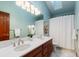 Stylish bathroom featuring double sinks, modern lighting, a skylight, and a shower with curtain at 8187 N Pinewood Dr, Castle Rock, CO 80108