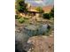 Beautiful front yard landscaping featuring a rock lined pond and mature plants at 8187 N Pinewood Dr, Castle Rock, CO 80108