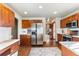 A modern kitchen with stainless steel appliances, wood cabinets, and hardwood floors under recessed lighting at 8187 N Pinewood Dr, Castle Rock, CO 80108