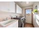 A modern laundry room with a large sink, a new washer and dryer, and plenty of storage space at 8187 N Pinewood Dr, Castle Rock, CO 80108