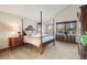 Bright main bedroom with carpet, vaulted ceiling, 4 poster bed, large window, and stylish wooden furniture at 8187 N Pinewood Dr, Castle Rock, CO 80108