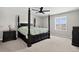 The primary bedroom includes a four-poster bed, ceiling fan, and a dresser, with a window letting in natural light at 5336 Trails Edge Ln, Castle Rock, CO 80104